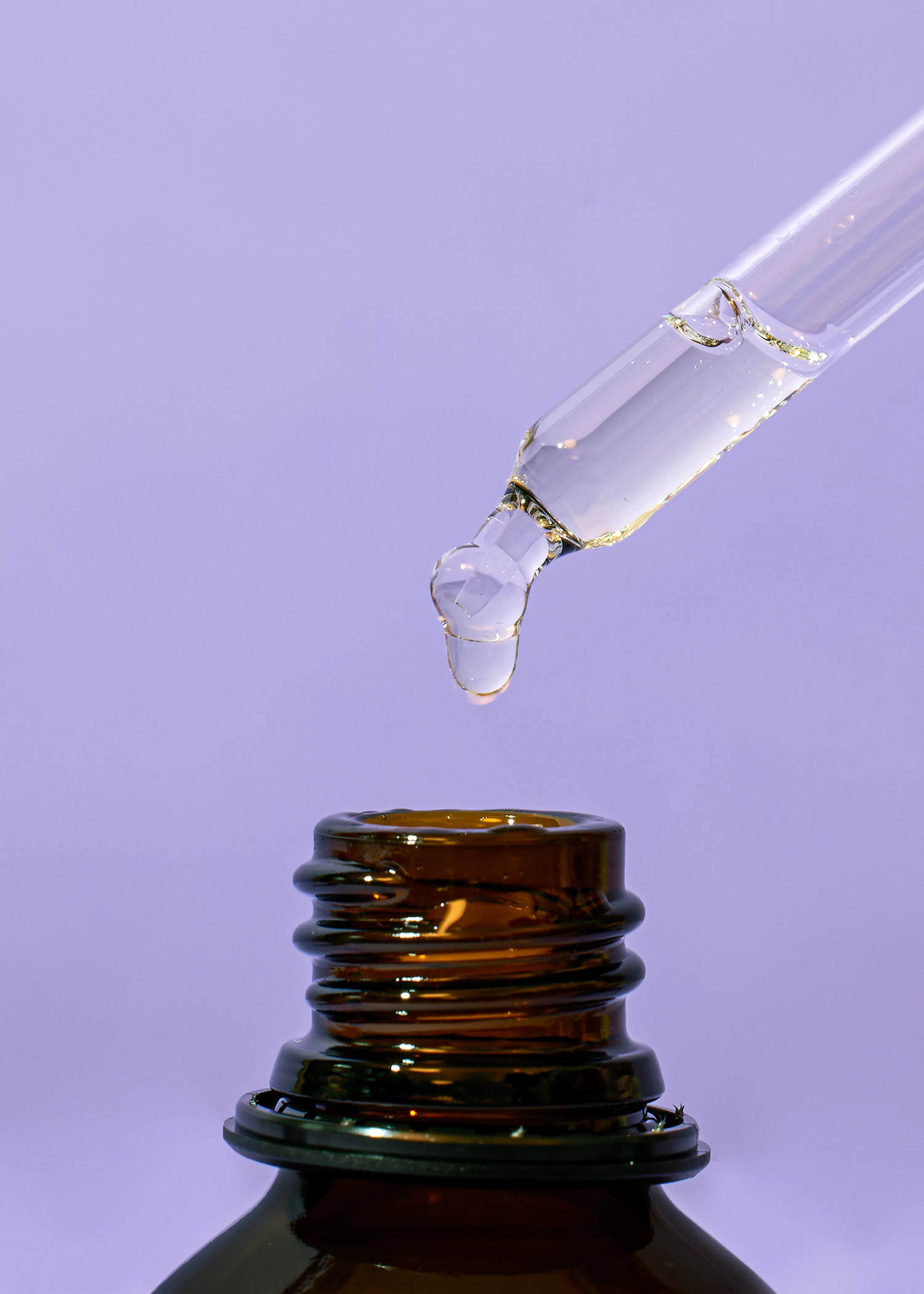 eine Tropfpipette gießt eine Flüssigkeit in eine Glasflasche